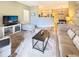 Open-concept living area with a large TV, comfortable seating, and kitchen view at 9390 W Chatfield Pl # 103, Littleton, CO 80128