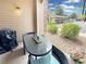 Outdoor patio with a glass table, grill, and seating with a view of the community at 9390 W Chatfield Pl # 103, Littleton, CO 80128