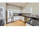 Bright kitchen features stainless steel appliances, granite countertops, white cabinets, and hardwood floors at 7580 S Monaco Way, Centennial, CO 80112