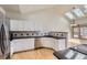 Bright kitchen has white cabinets, stainless steel appliances, granite countertops, and three skylights at 7580 S Monaco Way, Centennial, CO 80112