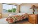 Well-lit bedroom with large window and floral bedspread at 6534 S Union Way, Littleton, CO 80127