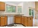 Clean kitchen with stainless steel dishwasher, granite countertops, and wood cabinets at 6534 S Union Way, Littleton, CO 80127