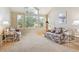 Bright living room featuring a vaulted ceiling, large windows, and floral print sofa at 6534 S Union Way, Littleton, CO 80127