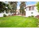 Large backyard with well-manicured lawn, mature trees, outdoor seating, and lush landscaping at 2715 W 37Th Ave, Denver, CO 80211