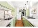 Modern kitchen with green cabinets, stone backsplash, and stainless steel appliances at 2715 W 37Th Ave, Denver, CO 80211