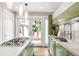 Modern kitchen boasts green cabinetry, stainless steel appliances, and a view to outdoor patio at 2715 W 37Th Ave, Denver, CO 80211