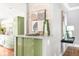 Stylish kitchen featuring green cabinets, stone backsplash, and modern decor at 2715 W 37Th Ave, Denver, CO 80211