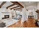 Open-concept living room with fireplace, exposed beams, and hardwood floors flowing into the dining area at 458 Adams St, Denver, CO 80206