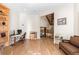 Open living room with hardwood floors, a built-in bookcase, and a unique staircase at 175 Harrison St, Denver, CO 80206