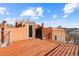 Spacious rooftop deck with wood flooring, metal railings, and access door to the home at 175 Harrison St, Denver, CO 80206