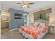 This primary bedroom features a ceiling fan, ensuite bath, and large window at 534 E 7Th Ave # 101, Denver, CO 80203