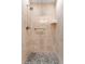 Shower featuring tan tiling, river rock floor, and chrome fixtures at 534 E 7Th Ave # 101, Denver, CO 80203
