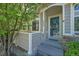 Charming home featuring a covered front entrance, decorative shrubs and a secure storm door at 4006 E Geddes Cir, Centennial, CO 80122