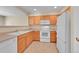 Functional kitchen with white appliances, tile flooring, and natural wood cabinetry, offering ample storage at 4006 E Geddes Cir, Centennial, CO 80122