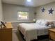 Bright bedroom with a large window, neutral walls, and a comfortable bed with patterned bedding at 5479 E Weaver Ave, Centennial, CO 80121