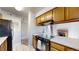 Bright kitchen with wooden cabinets, black appliances, and open access to living area at 12360 W Nevada Pl # 101, Lakewood, CO 80228