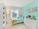 Bright bedroom with colorful accents, featuring a twin bed, dresser, and plenty of natural light at 9774 Burberry Way, Highlands Ranch, CO 80129