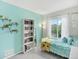 Bright bedroom with colorful accents, featuring a twin bed, bookcase, and plenty of natural light at 9774 Burberry Way, Highlands Ranch, CO 80129