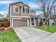 Charming two-story home boasts a two-car garage, neutral siding, and a well-manicured front yard at 9774 Burberry Way, Highlands Ranch, CO 80129