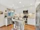 Bright kitchen features stainless steel appliances, light countertops, and wood floors at 9774 Burberry Way, Highlands Ranch, CO 80129