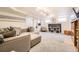 Spacious finished basement with large sectional, built-in shelving, and bright lighting perfect for living space at 944 S Euclid Way, Denver, CO 80209