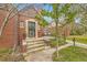 Inviting brick home featuring a cozy front porch and well-maintained landscaping, enhancing its curb appeal at 944 S Euclid Way, Denver, CO 80209