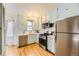 Charming kitchen featuring light blue cabinets, stainless steel appliances, and hardwood floors at 944 S Euclid Way, Denver, CO 80209