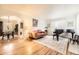 Bright living room featuring hardwood floors, a baby grand piano, and a comfortable seating area with floral artwork at 944 S Euclid Way, Denver, CO 80209