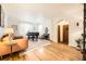 Sunlit living room featuring hardwood floors, grand piano, sofa, and an archway to the dining area at 944 S Euclid Way, Denver, CO 80209