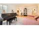 Cozy living room showcasing hardwood floors, a black piano, a comfortable sofa, and built-in shelving with decor at 944 S Euclid Way, Denver, CO 80209