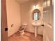 Simple half-bath with wood-look floors, pedestal sink, and ample lighting for a practical and clean space at 588 Stafford Cir, Castle Rock, CO 80104