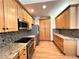 Galley kitchen featuring wood cabinets, stone countertops, stainless steel appliances and a mosaic backsplash at 588 Stafford Cir, Castle Rock, CO 80104