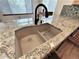 Close up of a kitchen sink, granite countertops, mosaic backsplash and wooden cabinets at 588 Stafford Cir, Castle Rock, CO 80104