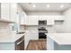 Modern kitchen with stainless steel appliances, white cabinets, and an island at 19018 E 94Th Pl, Commerce City, CO 80022