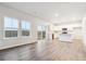 Bright living room featuring hardwood floors, large windows, and a sliding glass door to the outside at 19018 E 94Th Pl, Commerce City, CO 80022