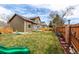 Beautifully landscaped backyard featuring a well-maintained lawn, mature trees, and a wooden fence at 4165 S Granby Cir, Aurora, CO 80014