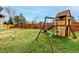 Backyard with a wooden playset, grass and a wood fence and landscaping at 4165 S Granby Cir, Aurora, CO 80014