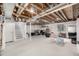 Unfinished basement featuring exposed beams, painted staircase, and bright neutral-toned carpet at 4165 S Granby Cir, Aurora, CO 80014