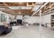 Spacious unfinished basement featuring exposed beams and bright neutral carpet and natural lighting at 4165 S Granby Cir, Aurora, CO 80014