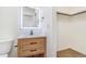 Modern bathroom vanity featuring a stylish mirror and open shelving for storage at 1219 Lilac Dr, Lochbuie, CO 80603