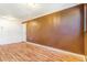 Spacious room with hardwood floors, wood paneling and a bright inviting atmosphere at 1219 Lilac Dr, Lochbuie, CO 80603