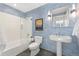 Stylish bathroom with blue patterned wallpaper, pedestal sink, framed mirror, and shower over tub at 1620 Little Raven St # 302, Denver, CO 80202