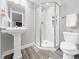 This bathroom has an updated shower and pedestal sink at 6002 Alkire Ct, Arvada, CO 80004
