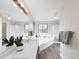 Bright bathroom with large mirror, double windows, tub, and shower featuring light-colored walls and wood-look tile flooring at 6002 Alkire Ct, Arvada, CO 80004