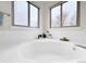 A soaking tub beneath two windows adds character to this bathroom at 6002 Alkire Ct, Arvada, CO 80004