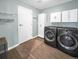 Laundry room with modern washer and dryer, storage cabinets, and ample space at 6002 Alkire Ct, Arvada, CO 80004