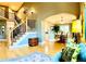 Open-concept living room featuring staircase, light hardwood floors, and dining area at 6002 Alkire Ct, Arvada, CO 80004