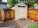 A storage shed sits beside a wooden fence, offering ample space for gardening equipment and outdoor tools at 6002 Alkire Ct, Arvada, CO 80004