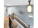 Stairway with natural wood steps, black iron balusters, and a unique lighting fixture, set against soft blue-gray walls at 6002 Alkire Ct, Arvada, CO 80004