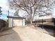 Large backyard featuring a detached garage, deck, mature trees, and a fully fenced in yard at 1853 S Filbert Ct, Denver, CO 80222